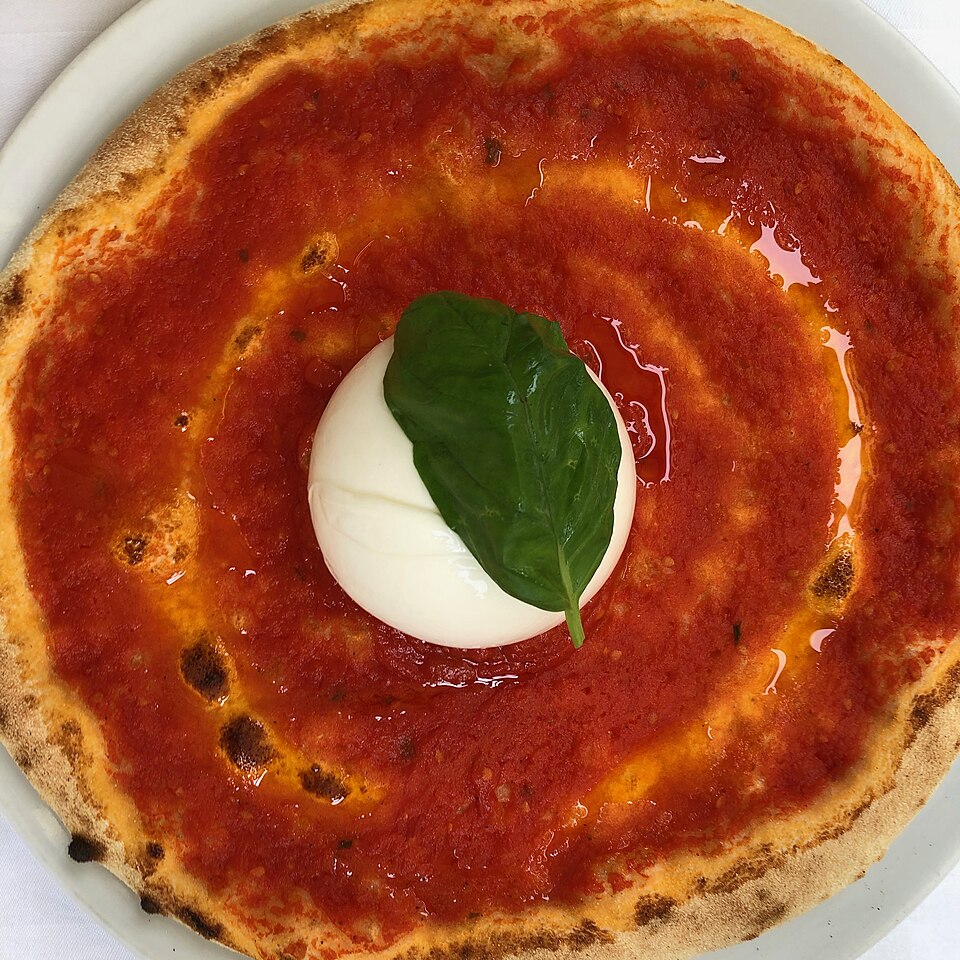 Pizza de burrata com tomates e manjericão sobre a mesa